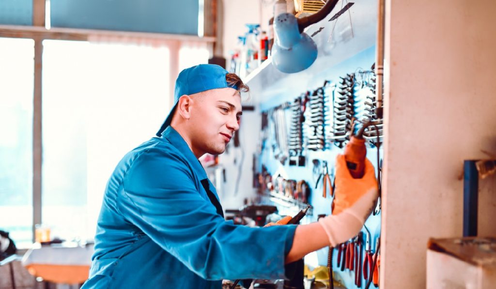 overhead storage rack woodsmith Young Mechanic Taking Wire Soldering Iron In Workshop